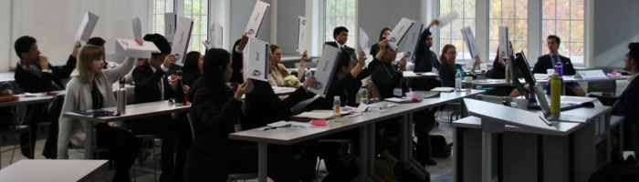 Model UN group in action. Students holding country signs in the air.