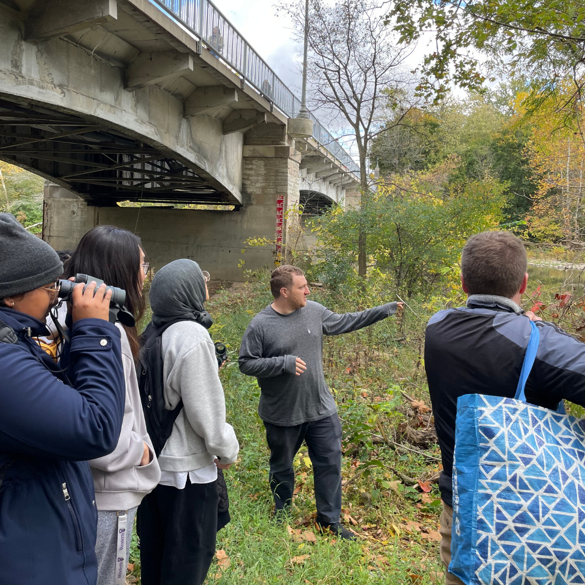 People standing outside observing the river